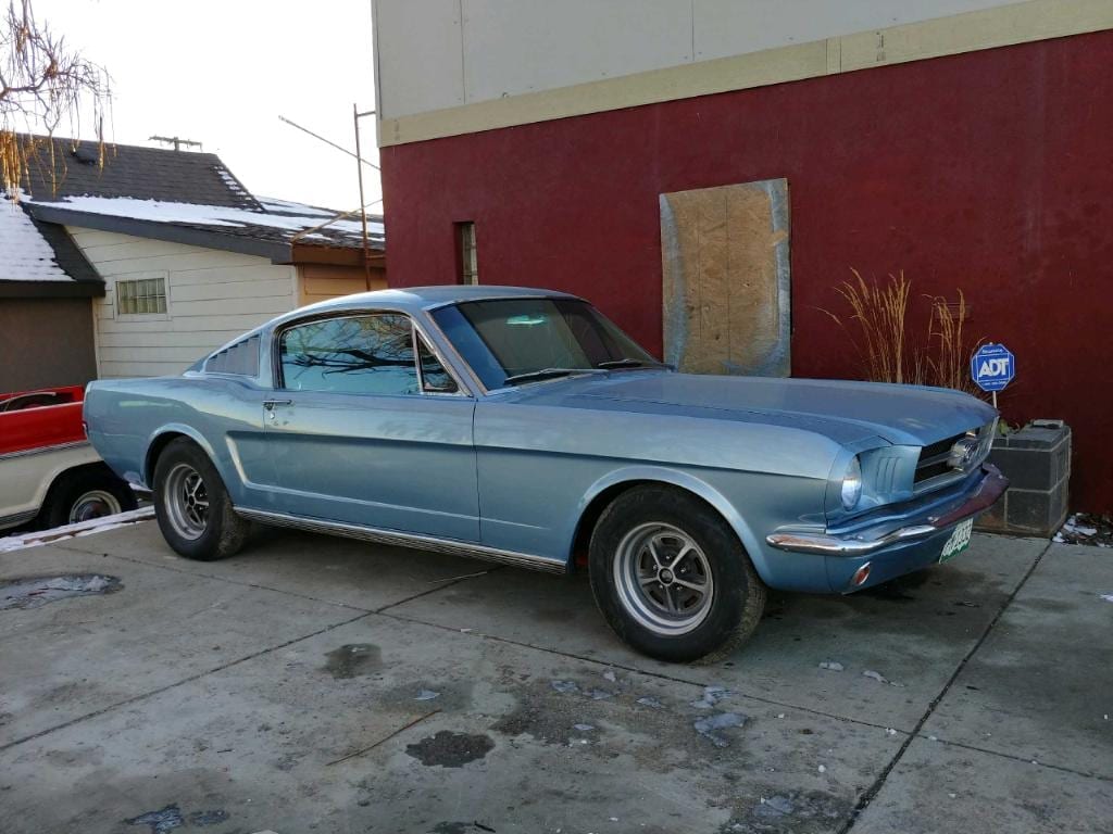 Light blue classic Ford Mustang fastback outside the shop
