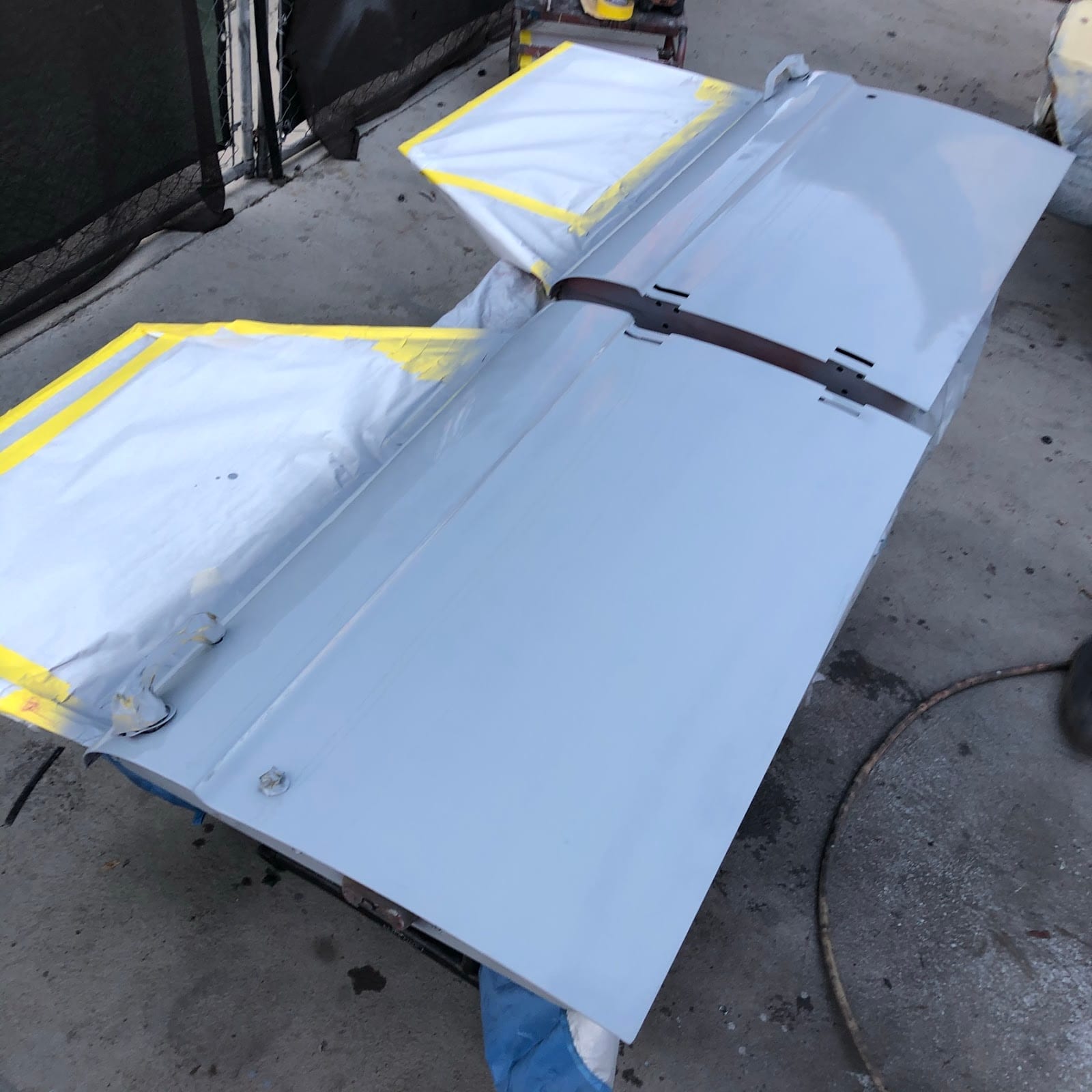 Car door panel in primer, masked and ready for paint